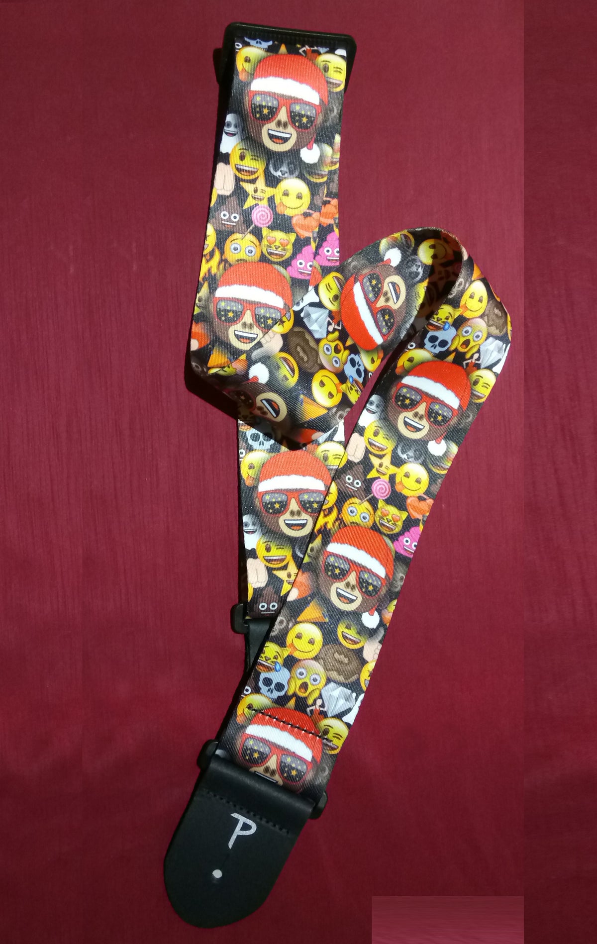 Guitar strap with emoji pattern on a red background