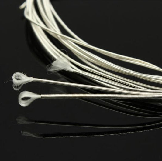 Silver guitar strings on a black background
