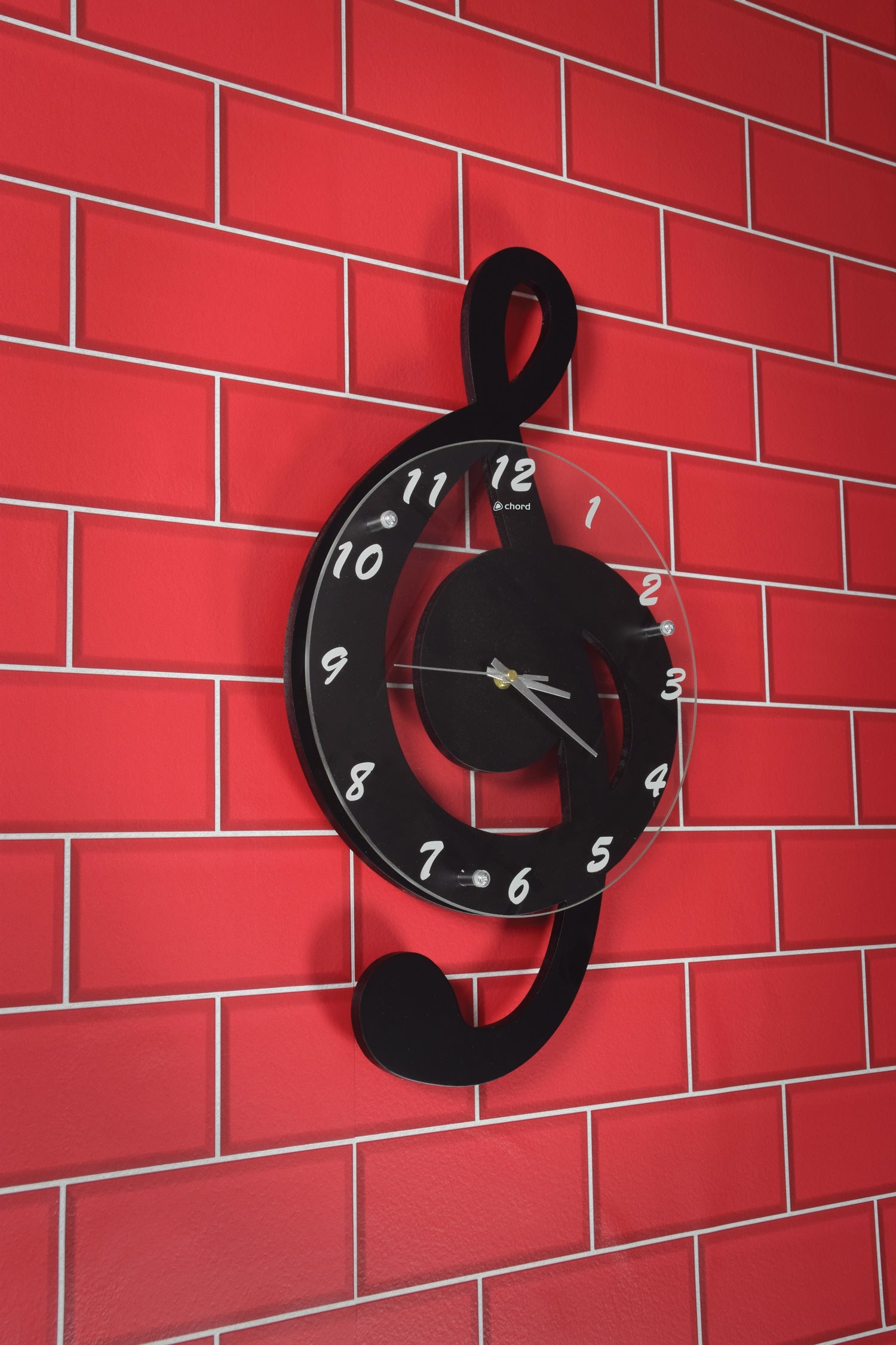 Black treble clef clock on a red brick wall