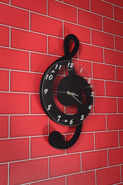 Black treble clef clock on a red brick wall