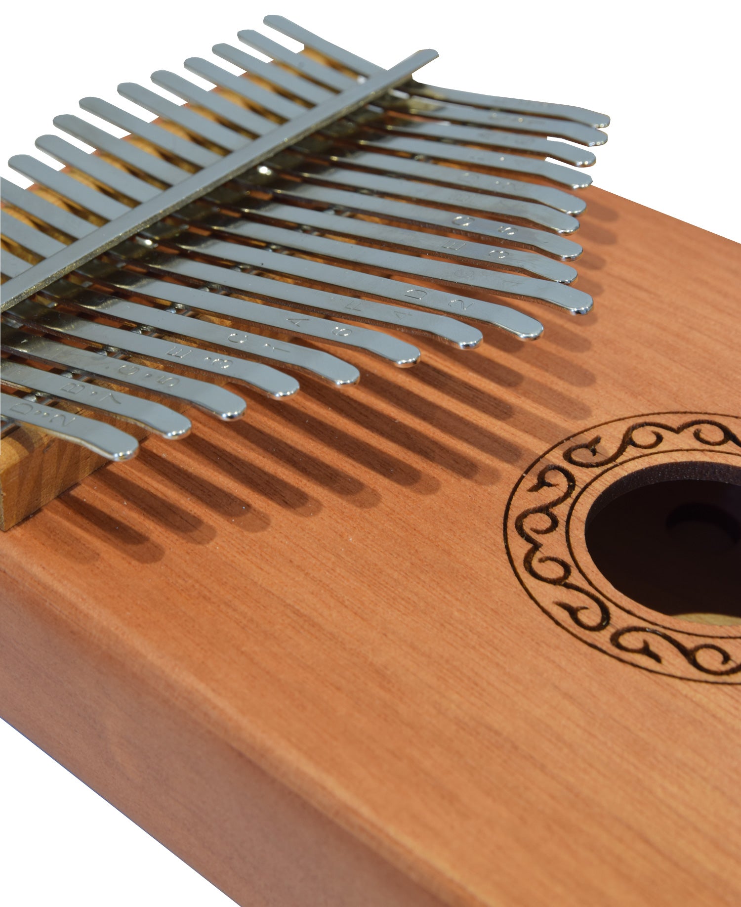 Close-up of a wooden kalimba with metal tines on a white background