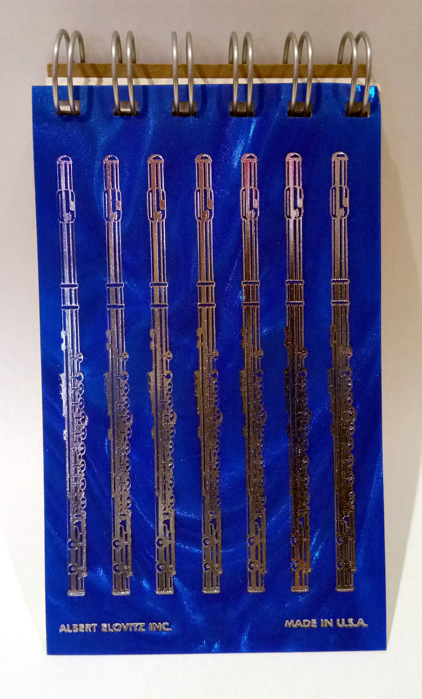 Notebook with flute designs on a blue cover against a grey background