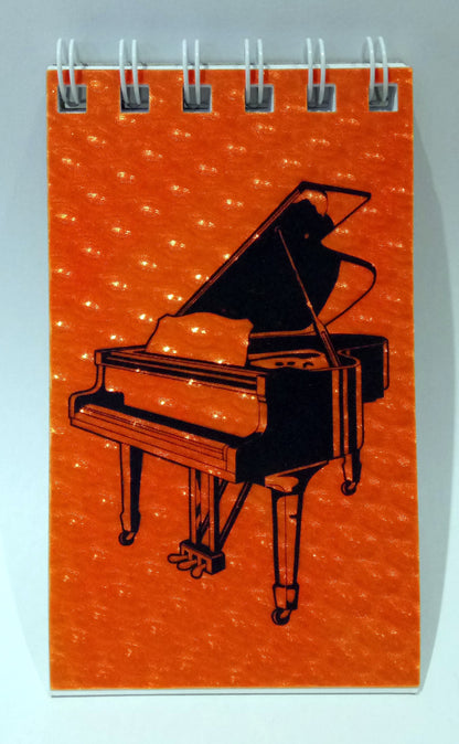 Notebook with a grand piano illustration on an orange cover