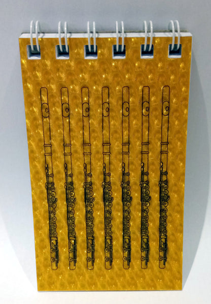 Notebook with flute designs on a yellow cover against a grey background