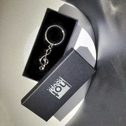 Keychain in a black box with 'hot house' branding on a reflective surface.