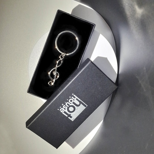 Keychain in a black box with 'hot house' branding on a reflective surface.