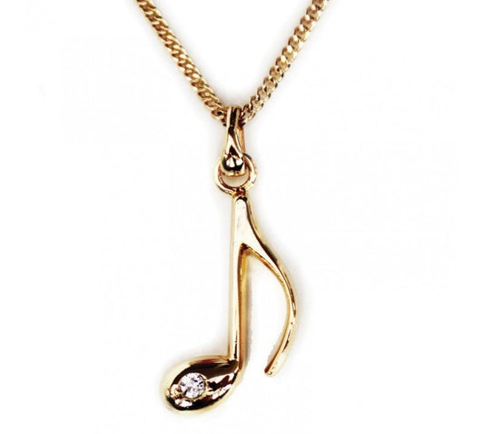 Gold plated necklace with a music note pendant on a white background