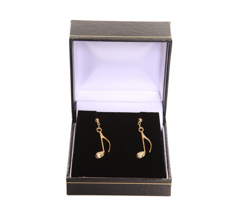 Gold plated note-shaped earrings in a black jewellery box with a white interior