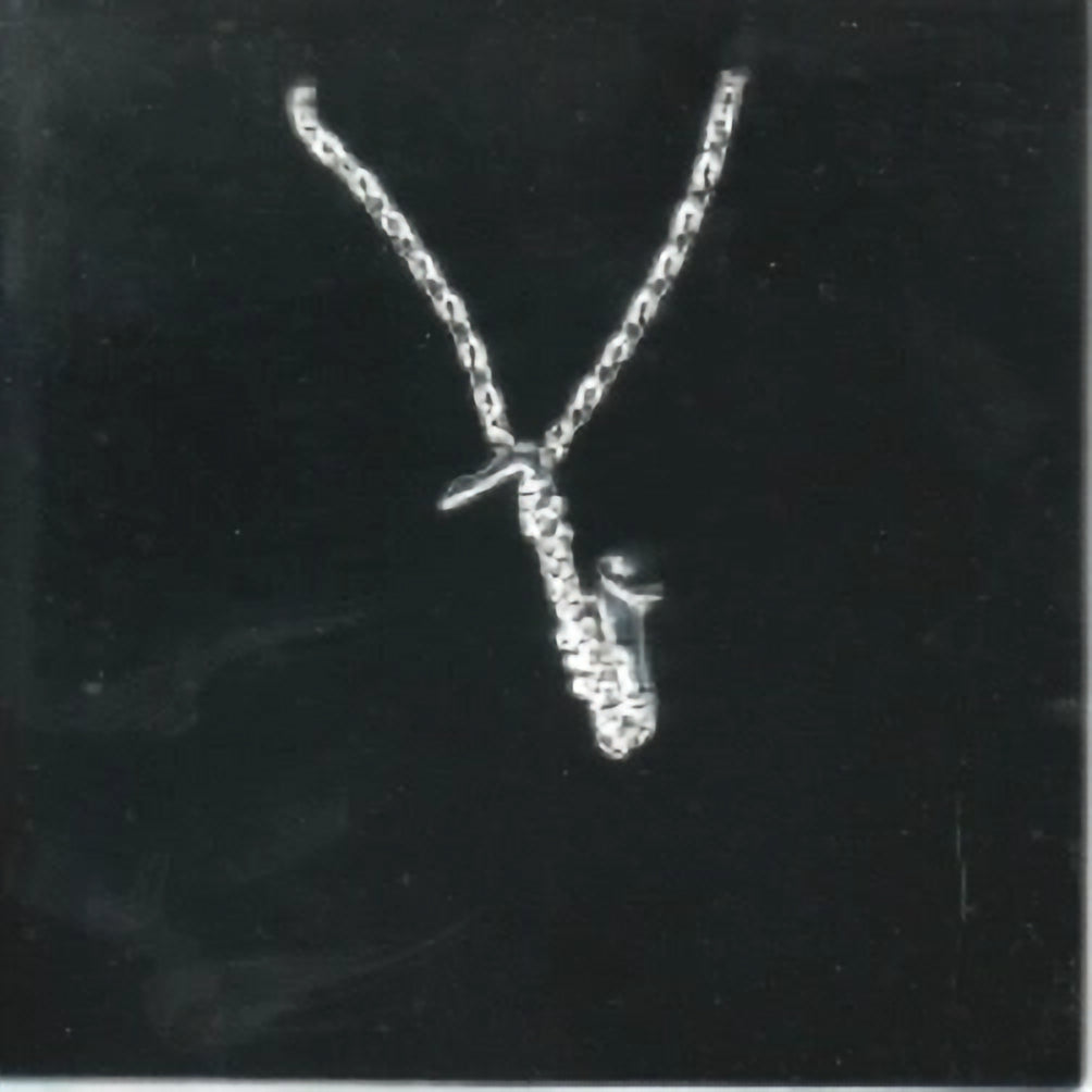 Silver plated sax shaped pendant and necklace on black background 