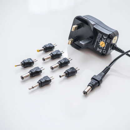 Black power adapter with multiple plugs on a white background