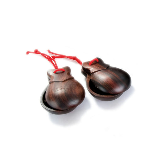 Pair of wooden castanets with red strings on a white background
