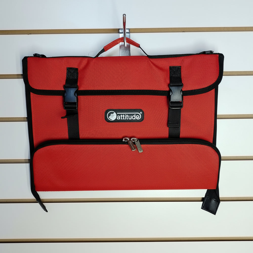 A red and black Attitude brand utility pouch or document bag hanging from a metal hook on a white slatwall. The bag features a top flap with two black plastic buckle straps, a central zippered pocket, and a bottom zippered compartment.