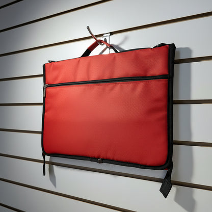 A red zippered pouch or document holder with black trim, hanging from a hook on a white slatwall.