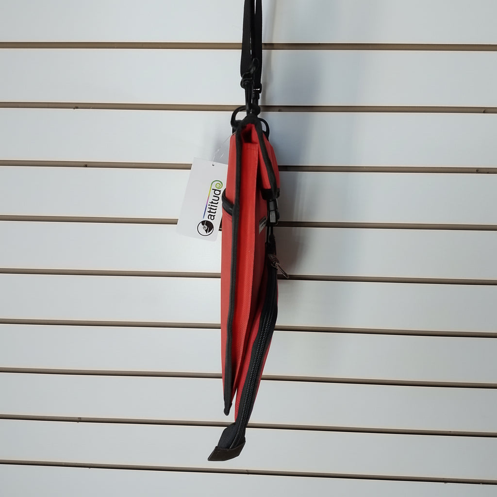 A side view of a red and black bag. the bag is photographed against a white slat   all.