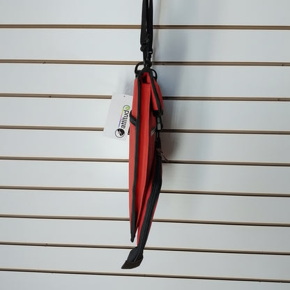 A side view of a red and black bag. the bag is photographed against a white slat   all.