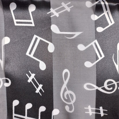A close-up of a fabric or mesh black material with a repeating white music notes.