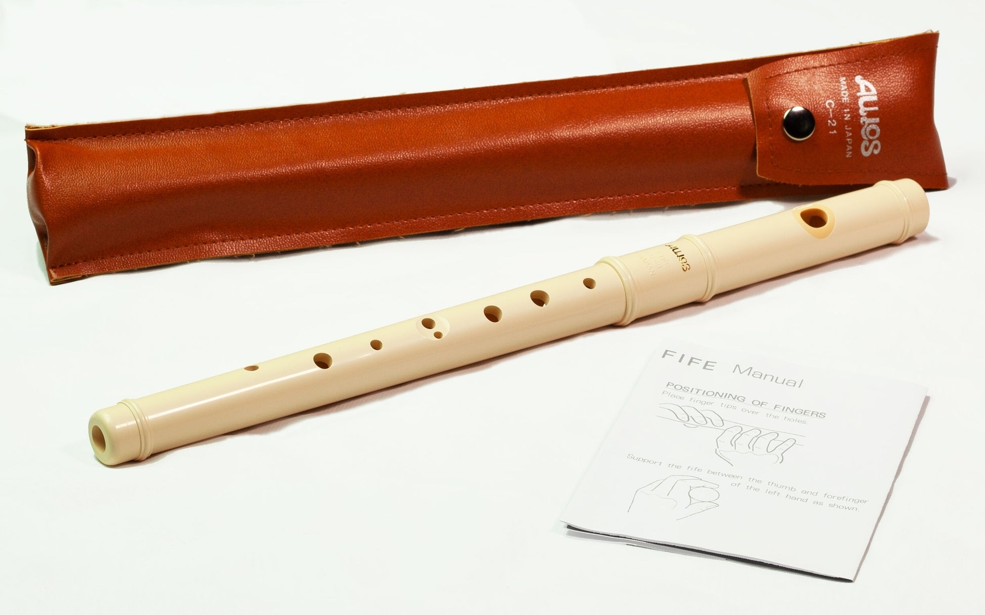 Flute with leather case and instruction sheet on a white background