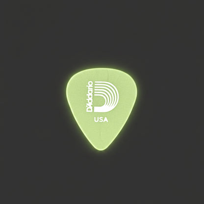 A single D'Addario guitar pick with a white logo and 'USA' text, displayed on a textured dark gray background.