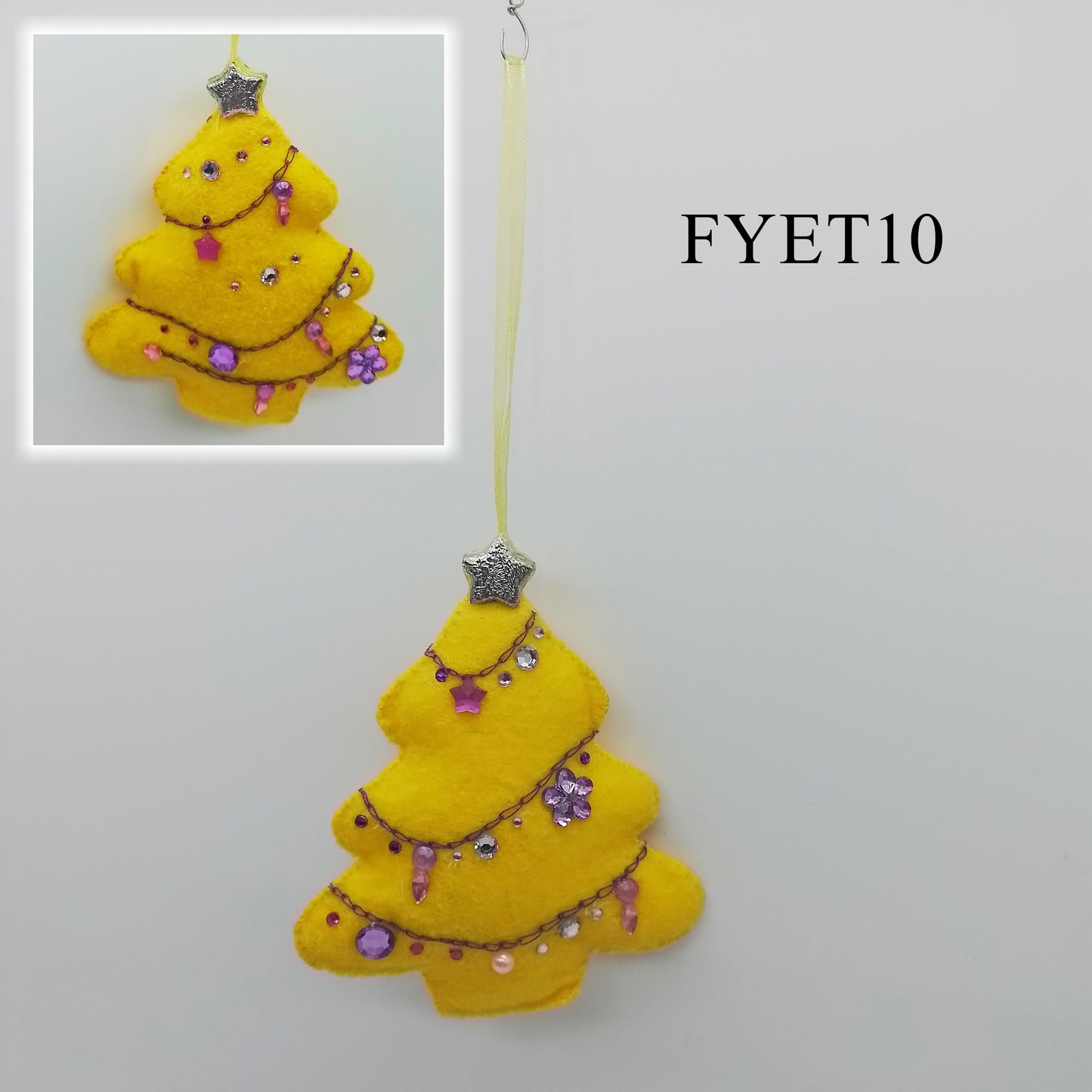 Brighten your holiday season with a dash of colour!
A yellow felt decoration shaped like a tree, it's decorated with a chain stitch needlework, rhinestones of various shapes and sizes, and two silver stars.
A yellow, thin ribbon is attached to one end to form the hanger.