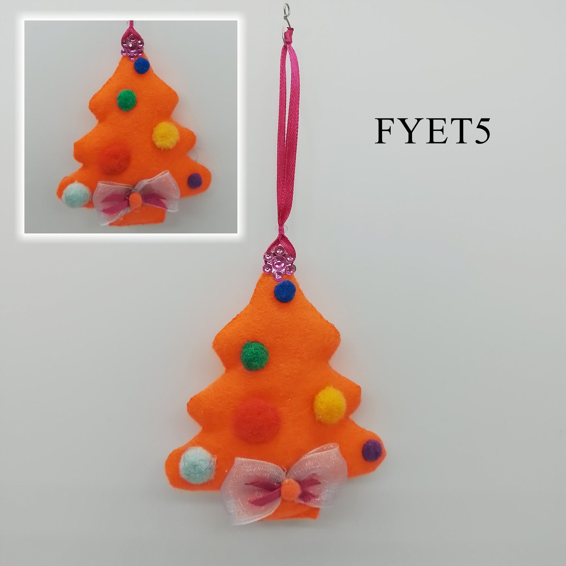 The bright orange material contrasts with the vivid colours, creating a festive appearance.
A pink, thin ribbon is attached to one end to form the hanger.