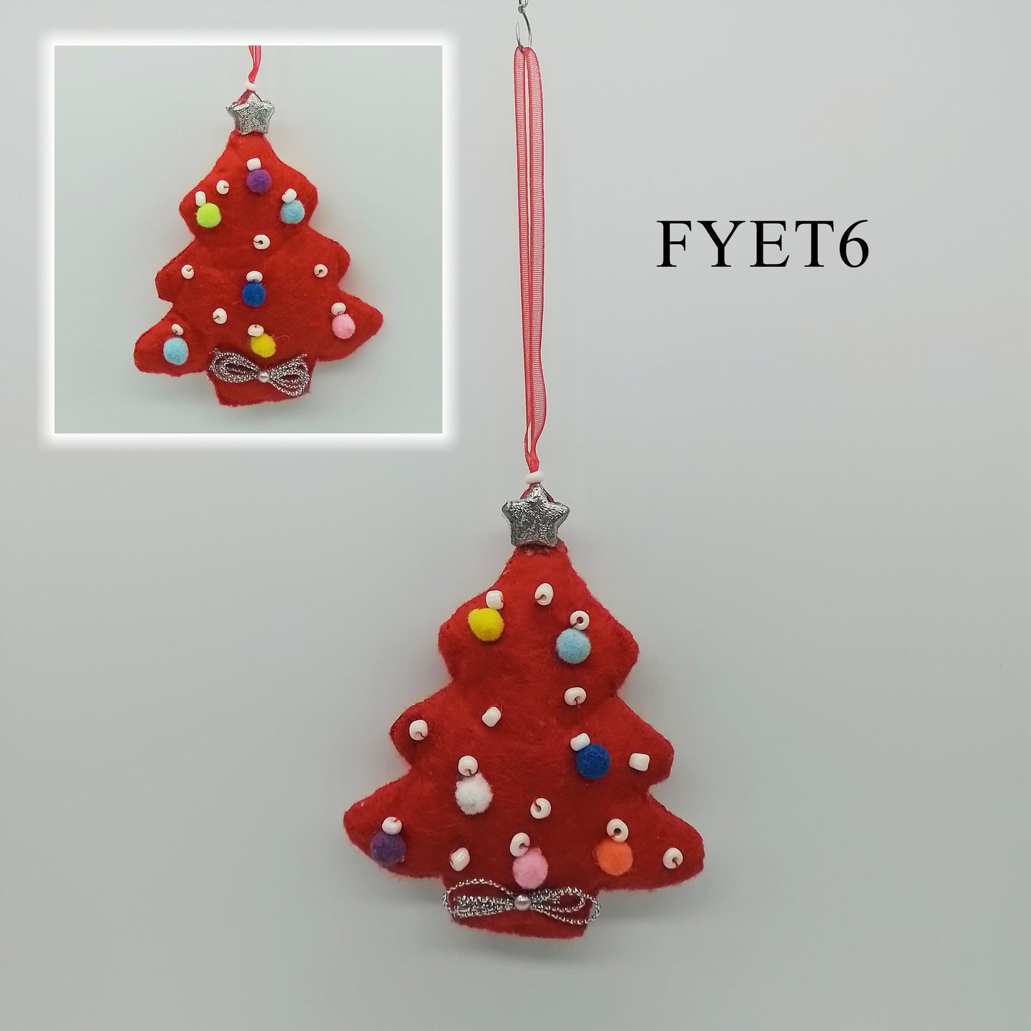 A red felt tree-shaped ornament is adorned with tiny colourful pom-poms and white beads. A silver bow and a silver star adds a festive touch to the ornament on both sides.
A red, thin ribbon is attached to one end to form the hanger.