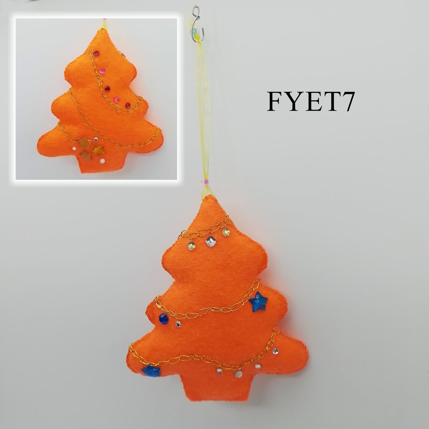 A vibrant Christmas tree ornament decorated with sparkly rhinestones in various sizes, and hand-embroidered chain stitch.
A yellow, thin ribbon is attached to one end to form the hanger.