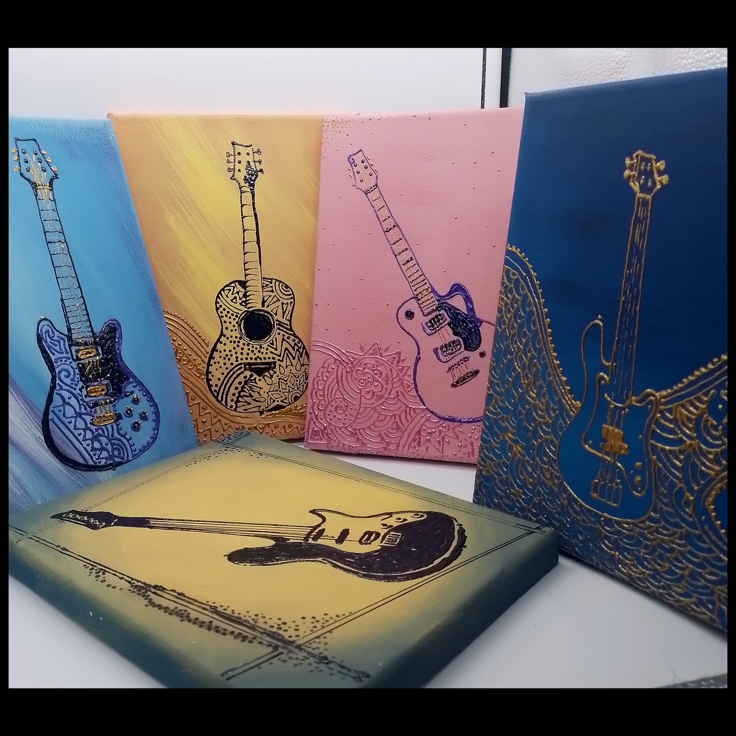 Five acrylic guitar and bass guitar illustrations on canvas. The shape of the  instrument can be felt under the finger tips as it is a light relief.  