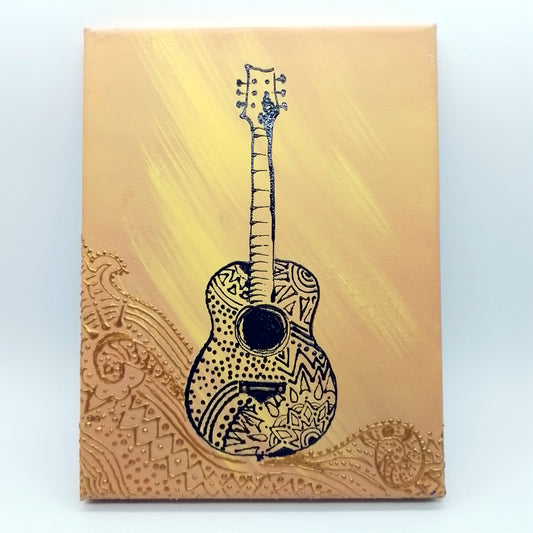 Black acoustic guitar on two tone orange and gold detail. The shape of the instrument is a light relief on a flat surface.