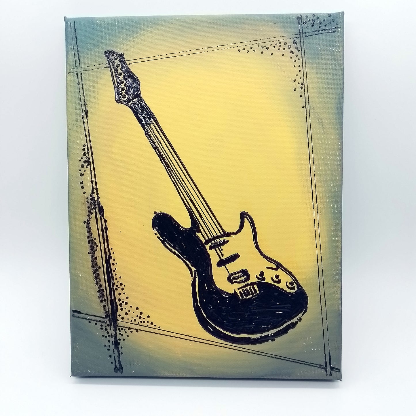 Black electric guitar on forest green and yellow background. The shape of the instrument is a light relief on a flat surface.