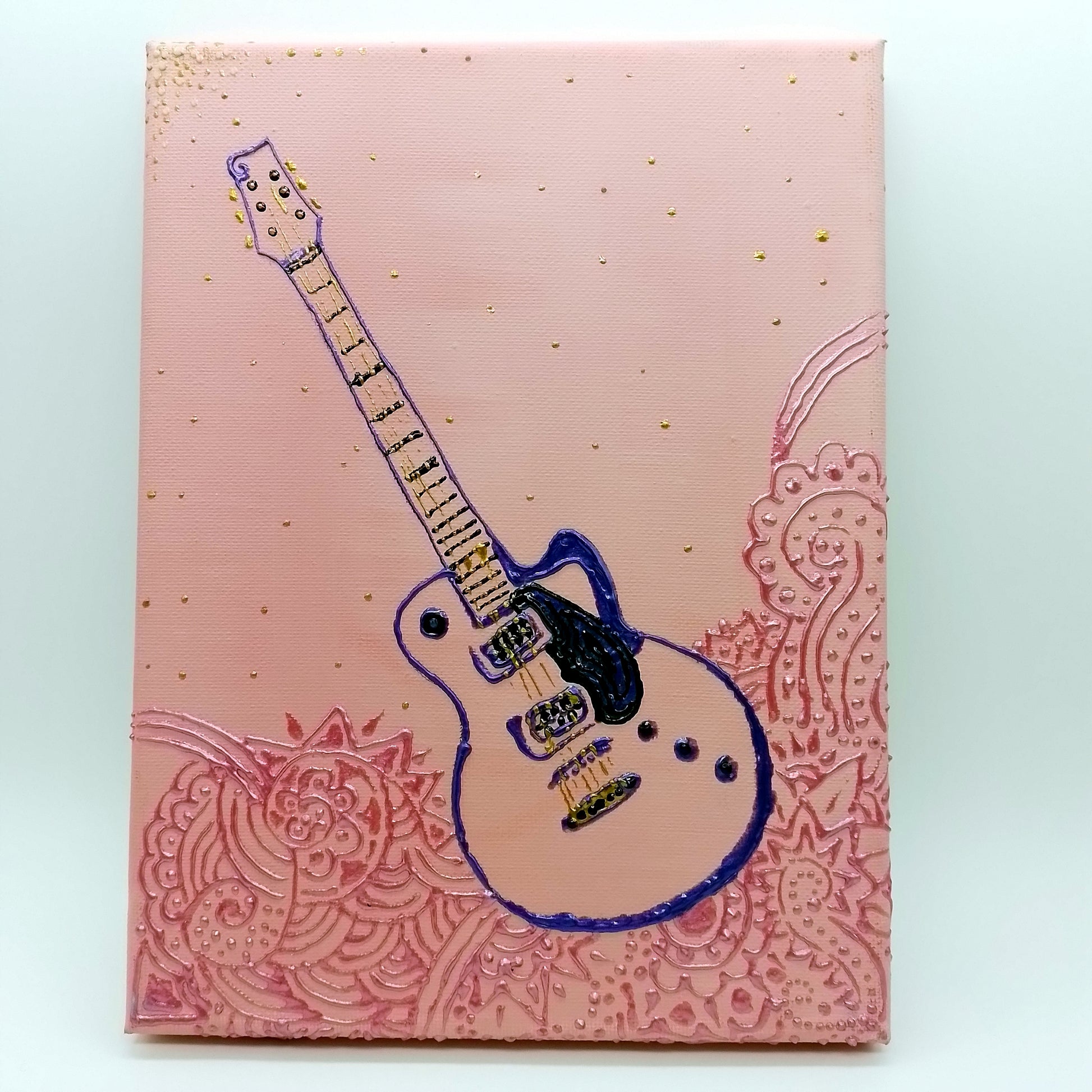 Purple, black and gold electric guitar and pink decorative elements on light pink  background. The shape of the instrument is a light relief on a flat surface.