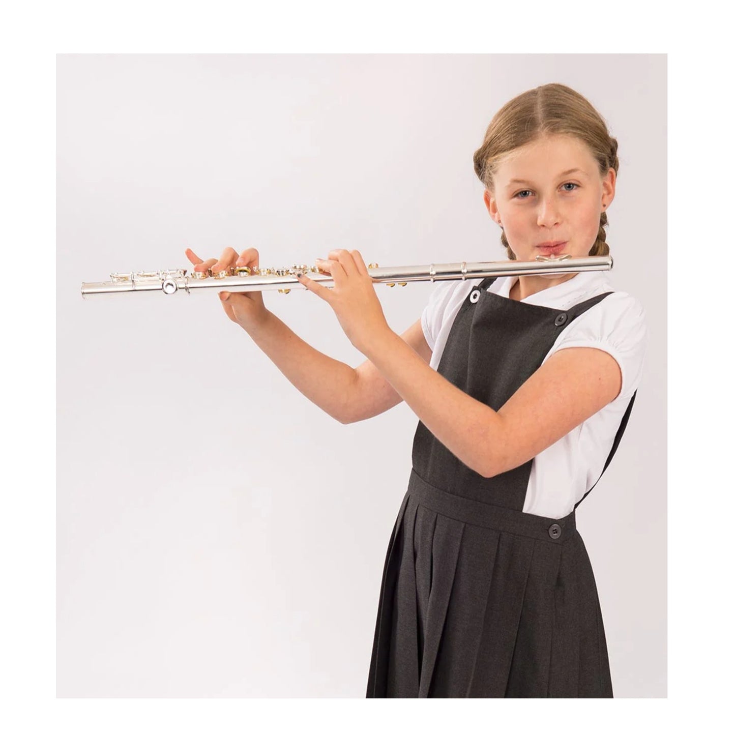 A child in school uniform playing the flute