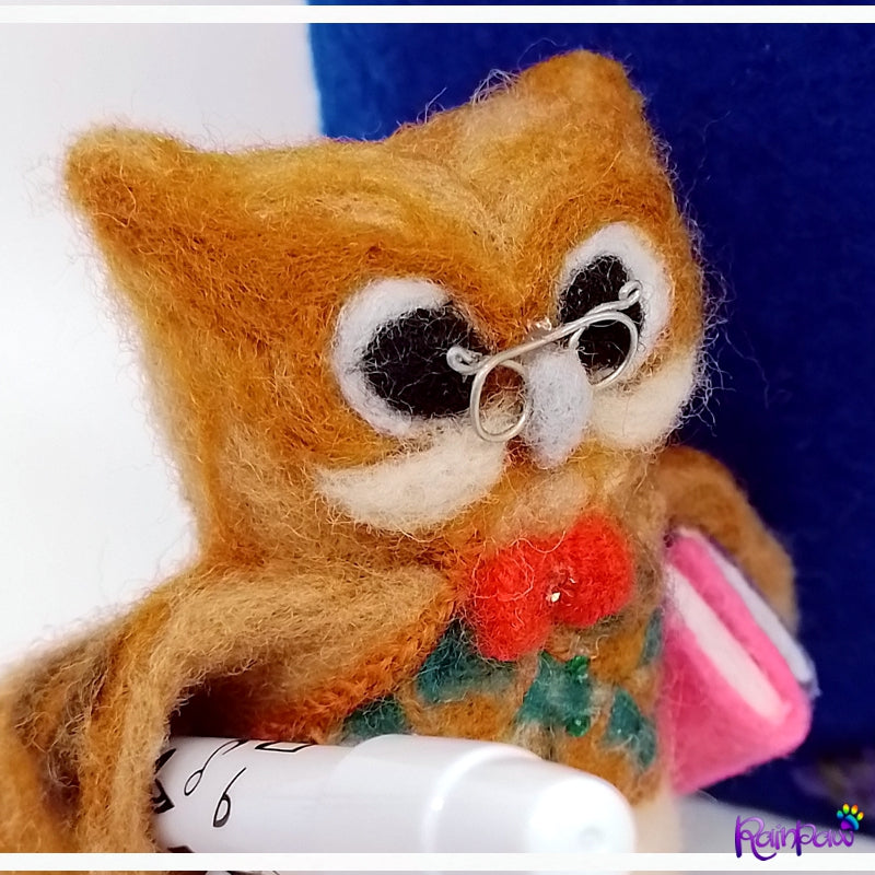 Felted owl wearing glasses with a bow tie on a white background