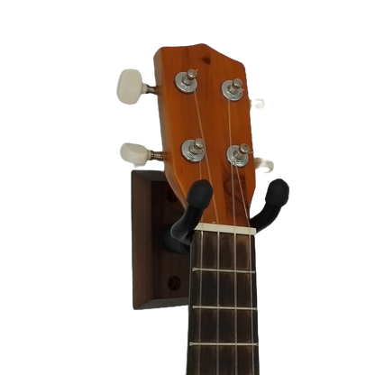Ukulele headstock with a wall-mounted guitar hanger on a white background