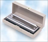 Harmonica in a wooden case on a light blue background