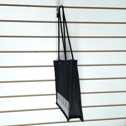 A sideview of a black Music Themed Reusable Shopping Bag, displayed on a white slatted wall.