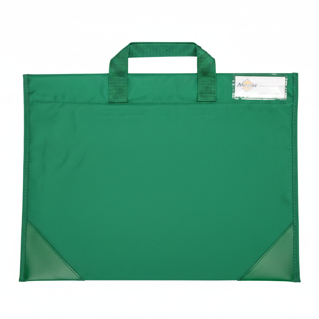 A green fabric school bag with single top handle and a clear plastic label pocket the upper corner. Photographed, laid flat on a white surface.