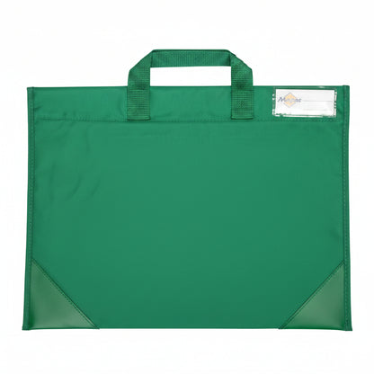 A green fabric school bag with single top handle and a clear plastic label pocket the upper corner. Photographed, laid flat on a white surface.