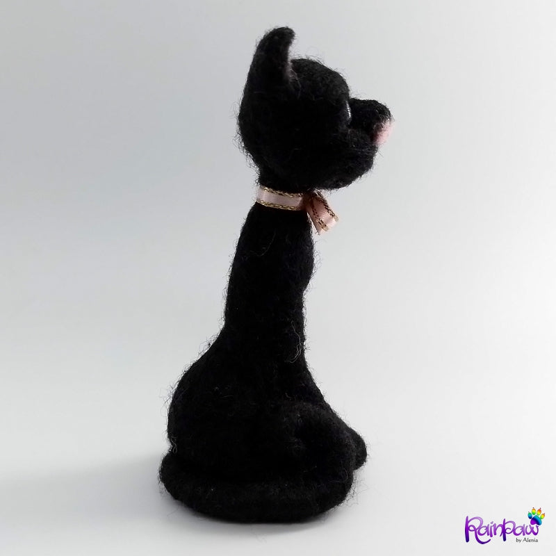Black cat with a pink bow on a white background