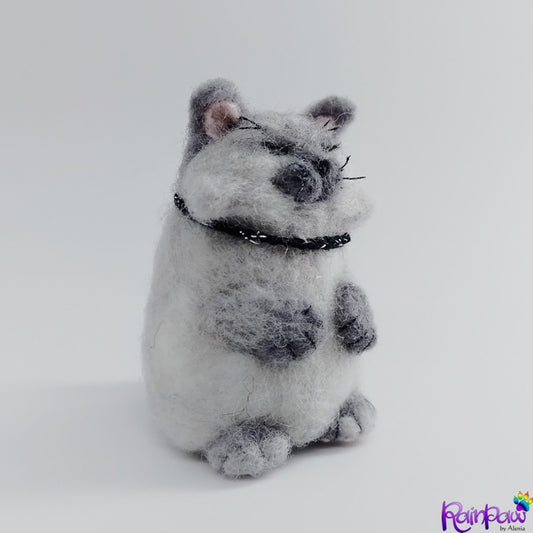 A figurine resembling a cat with black collar