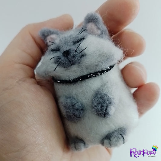 Small felt cat toy held in a hand with 'RainPaw' branding.
