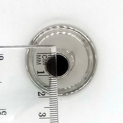 A view of the metallic circular side that attaches to the instrument with a ruler which indicates 1 cm 