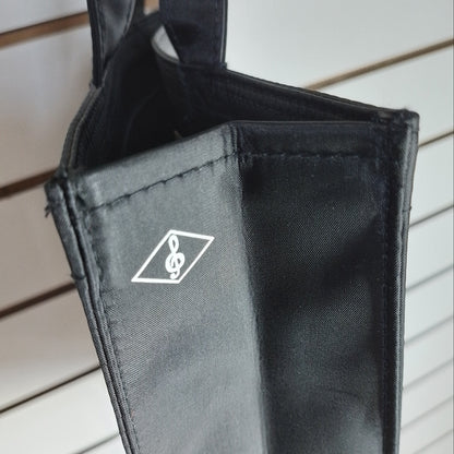 A close-up of a black fabric accessory, likely a bag or sleeve, featuring a white printed logo of a treble clef inside a diamond shape, set against a light-coloured slatted background.