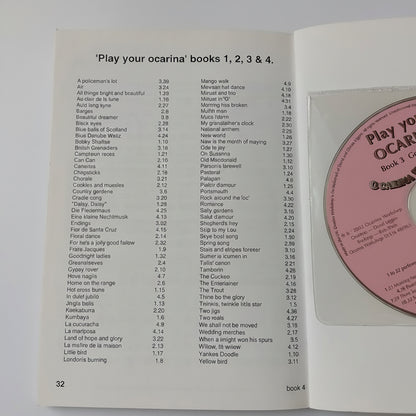 An open book or booklet showing printed sheet music titled 'Play your ocarina books 1, 2, 3 & 4' with a pink CD partially visible in the cover, photographed against a white background.