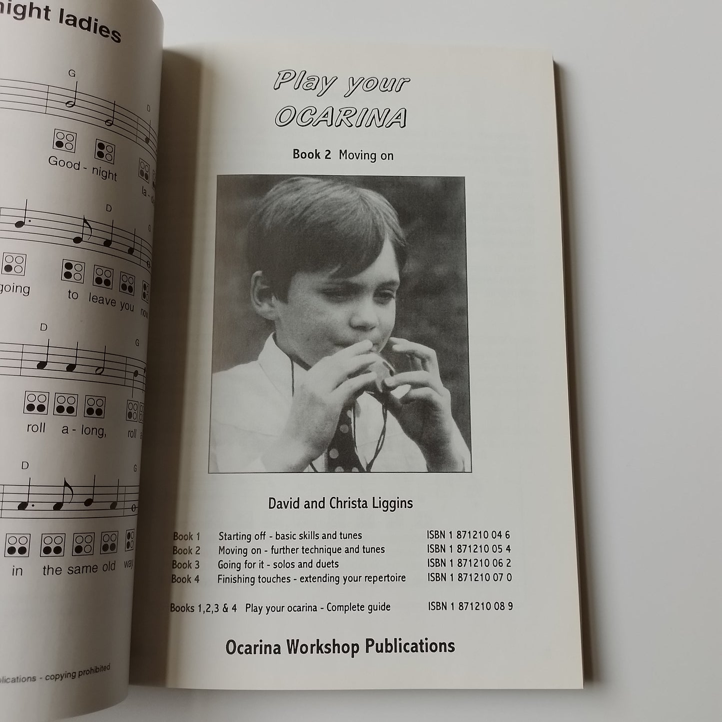 An open printed sheet music book or instruction booklet on a white background, showing the title 'Play Your Ocarina', a black-and-white portrait photo, and musical notation pages partially visible.