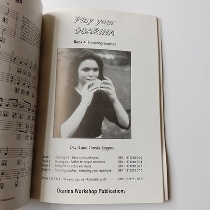 An open sheet music book showing the cover page for 'Play Your Ocarina Book 4' by David and Chrisa Loggins, with a black-and-white photo of a woman playing an ocarina. The page includes publication text and a second open page below with musical notation.