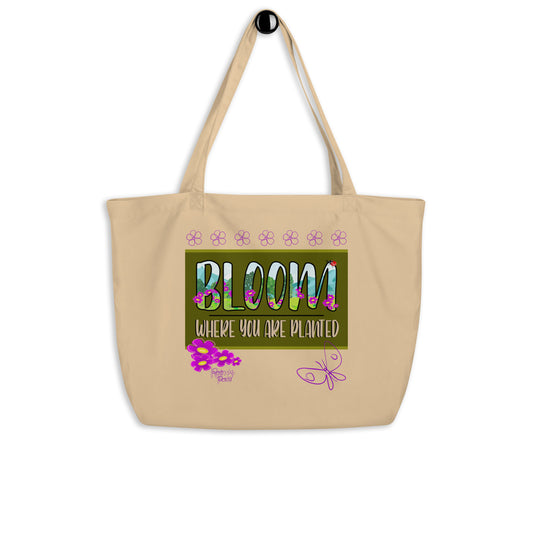 Beige tote bag with 'Bloom Where You Are Planted' text and floral designs on a white background