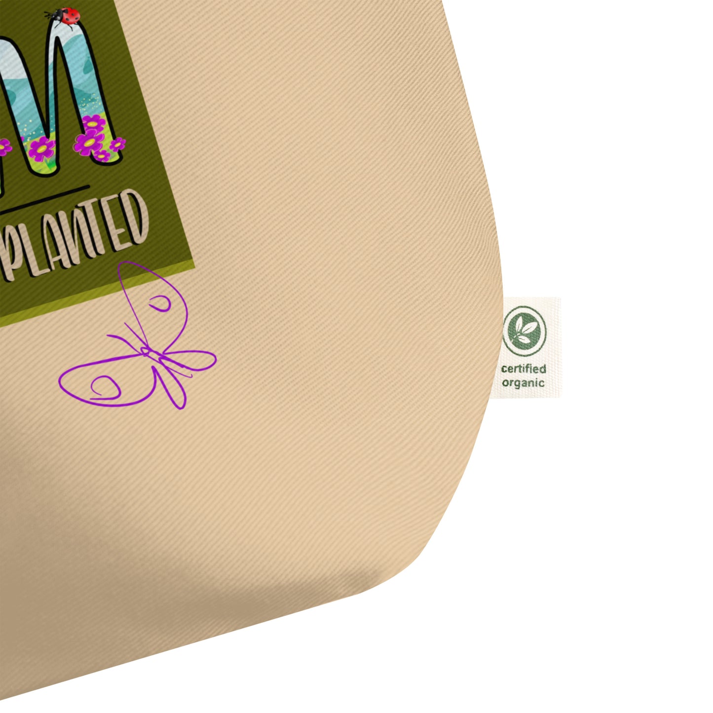 Beige bag detail with a green label featuring text and graphics, and a certified organic logo.