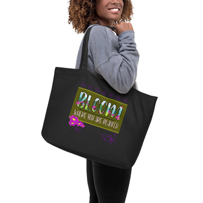 Person holding a black tote bag with an elephant design on a white background