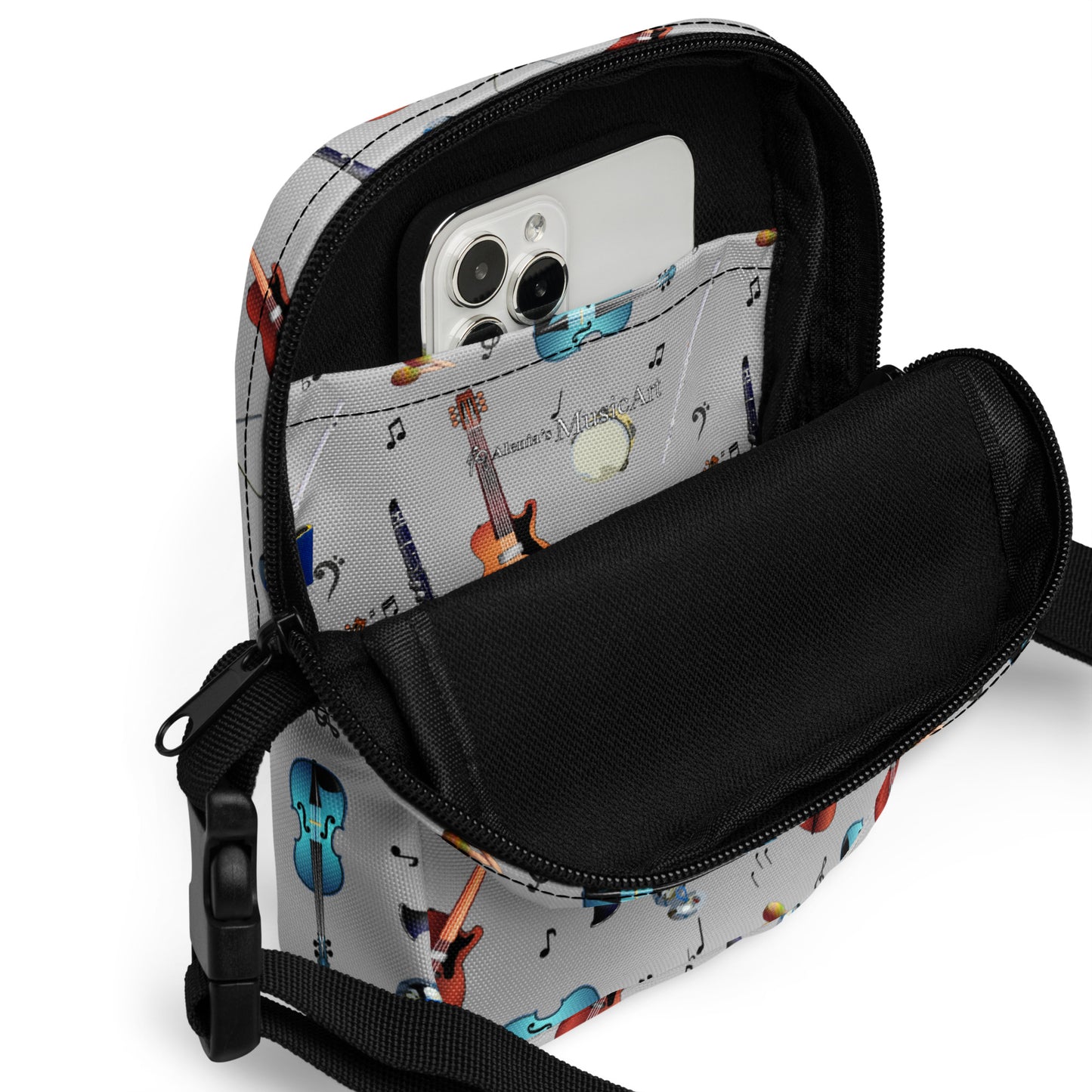 Grey crossbody bag with black adjustable shoulder strap (with black plastic clip), inside and outside pockets, sturdy fabric, and two-way zipper. The design features a repeat pattern of colourful musical instruments and black musical notes on a grey background.
