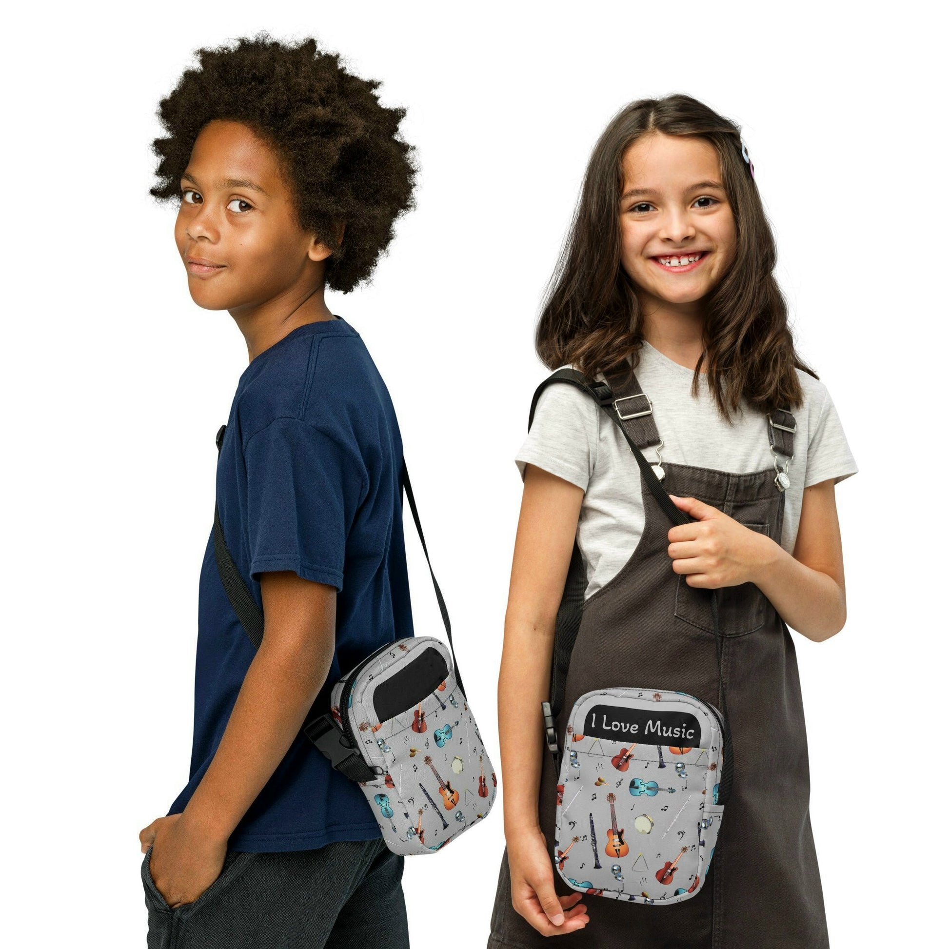 Grey crossbody bag with black adjustable shoulder strap (with black plastic clip), inside and outside pockets, sturdy fabric, and two-way zipper. The design features a repeat pattern of colourful musical instruments and black musical notes on a grey background.